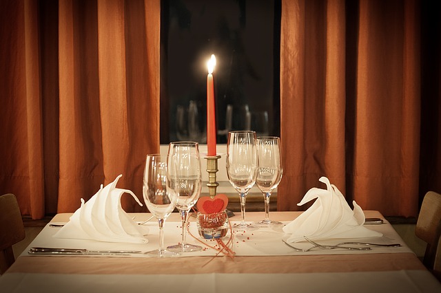 svíčka, skleničky, ubrousky, stůl